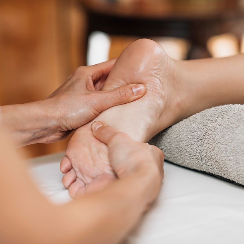 Uma mulher recebendo uma massagem nos pés em um spa.