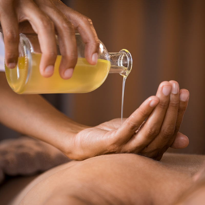 Uma mulher está recebendo uma massagem com um frasco de óleo.